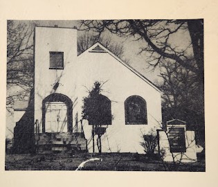 Black and white photo of the new location of Mt. Calvary Baptist church. Front gabled church, tower on left with stairs leading up to the double door entrance. There are two arched windows to the right of the entrance.